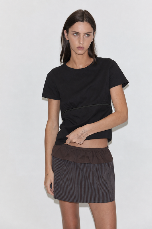A cropped front view of the Flounce Layer Mini Skirt - Brown Blue Stripe by Deiji Studios, a low-rise mini skirt in fine brown-blue stripe with a brown flounce layer at the waist, worn with a black tee against a plain white background.