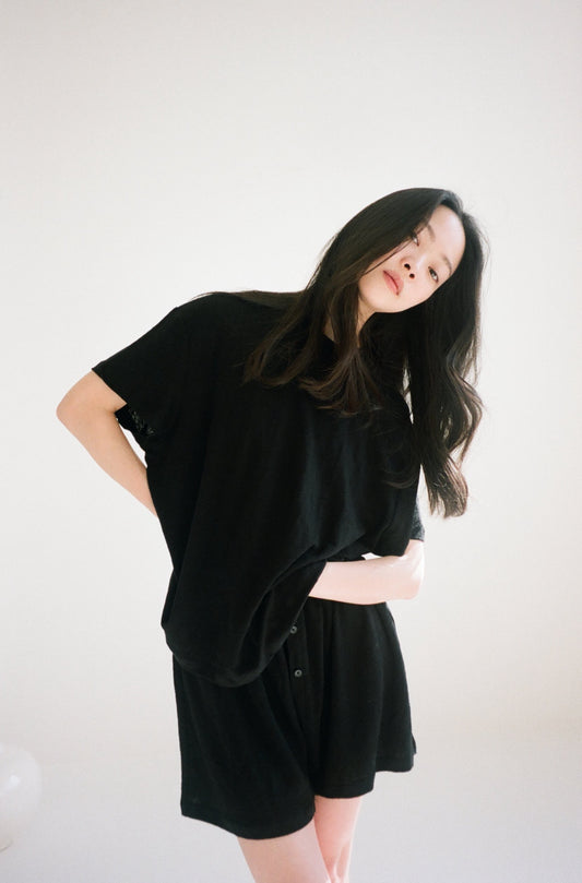 Female model wearing soft t shirt - black by Deiji Studios against plain background