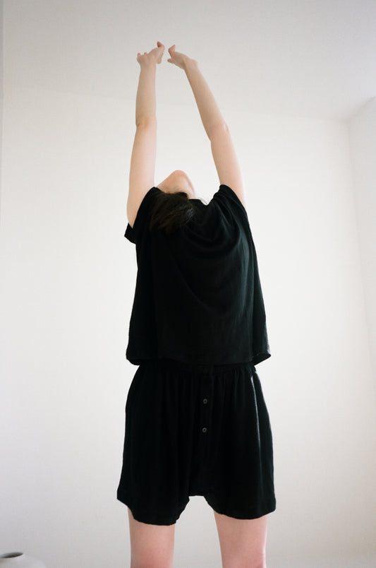 Female model wearing soft short - black by Deiji Studios against plain background