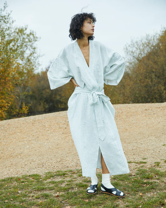 Female model in grass field wearing the 02 robe - river stripe by Deiji Studios