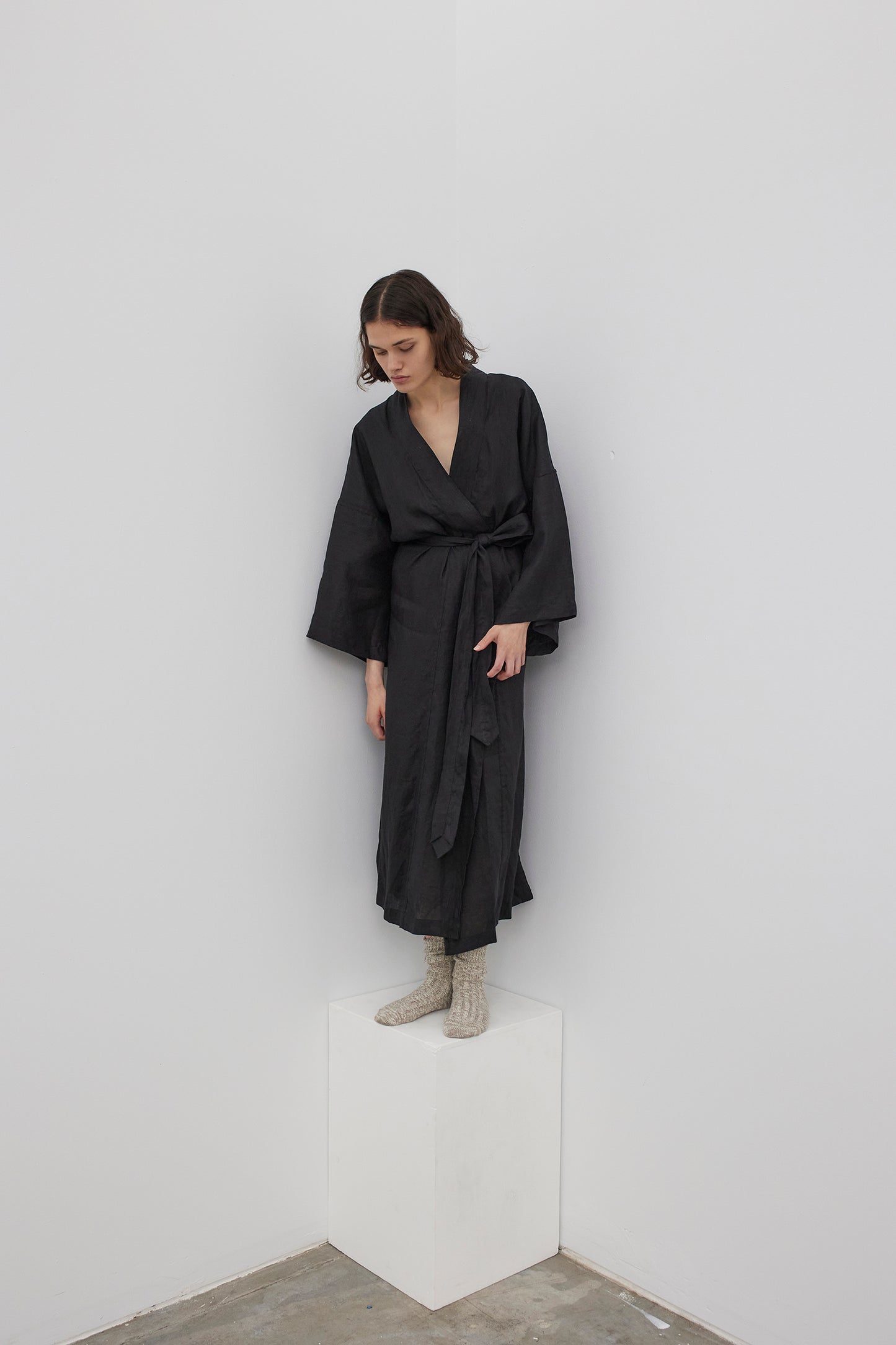 Female model wearing the 02 robe - deep black by Deiji Studios against plain background