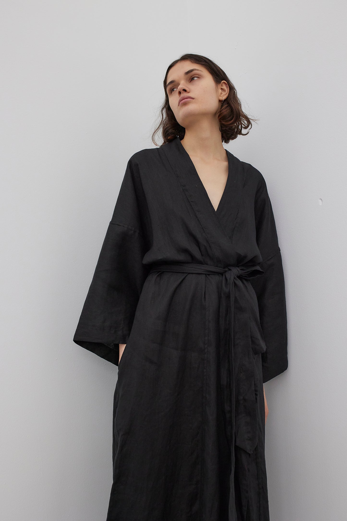 Female model wearing the 02 robe - deep black by Deiji Studios against plain background