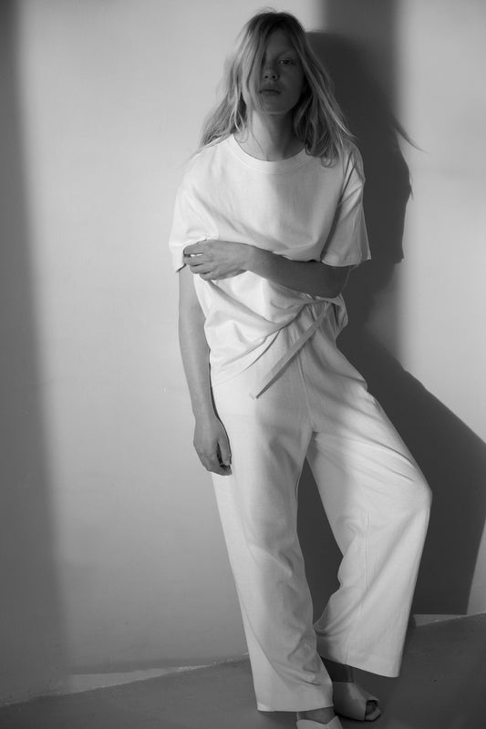 Female model wearing the jersey pant - bone by Deiji Studios against plain background