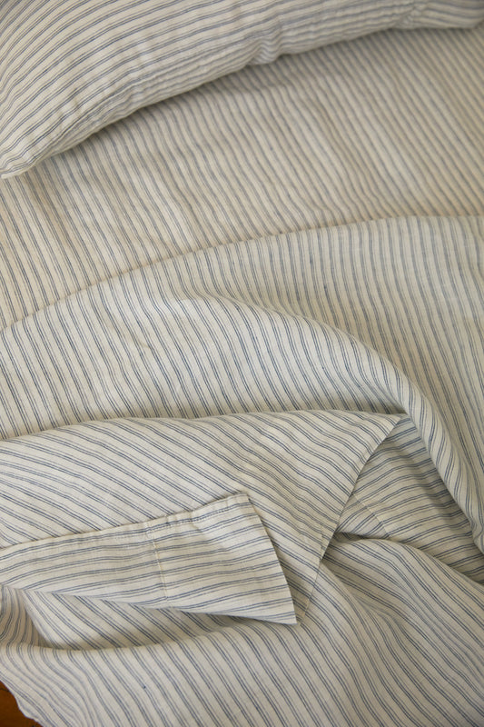 Light room with queen bed topped with Sheets - River Stripe by Deiji Studios
