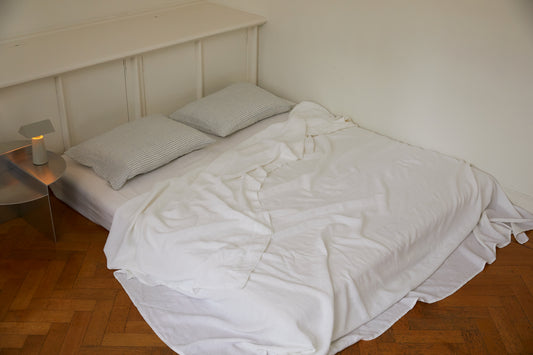 Light room with queen bed topped with Sheets - White by Deiji Studios